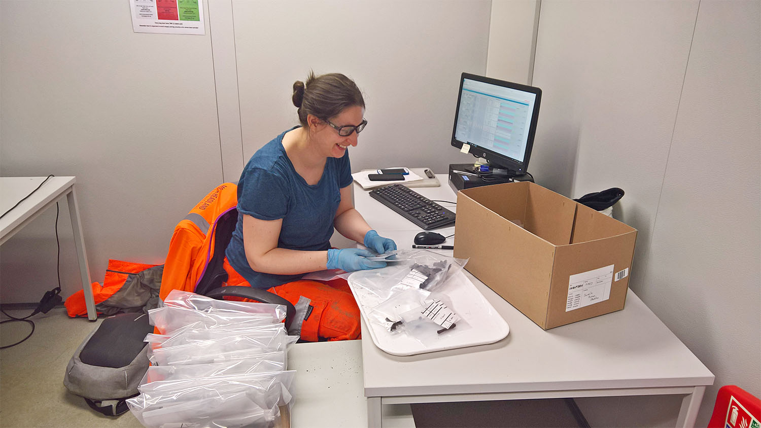 Sue McGalliard sits at a desk and works with ancient bone fragments.