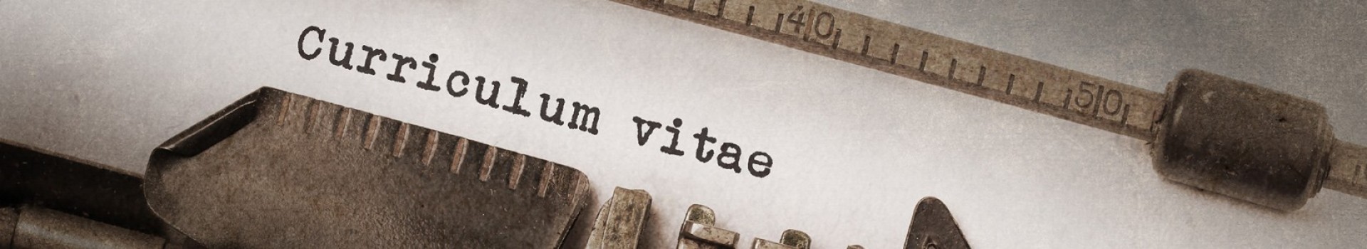 The words 'Curriculum Vitae' appear on paper in an old typewriter.