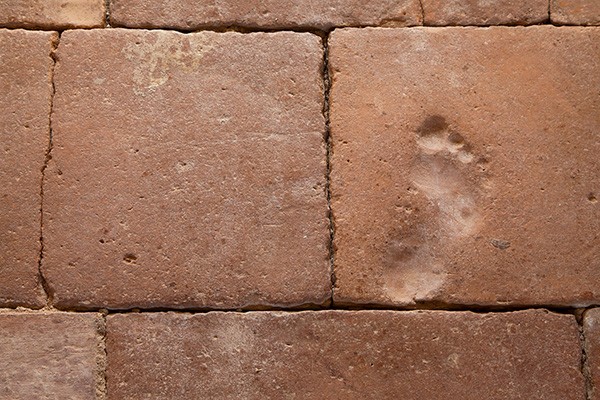 A child's footprint is embedded into ceramic tiles.