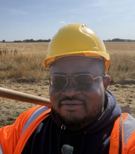 Photograph of Oluwadamilare wearing a hard hat and high-vis jacket