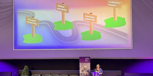 CIfA CEO Kate Geary on stage at CIfA Conference 2025 in front of a presentation that reads 'wicked problems small wins and CIfA's three year plan'