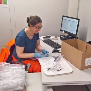 Sue McGalliard sits at a desk and works with ancient bone fragments.